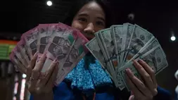 Karyawan menunjukkan uang pecahan rupiah dan dolar Amerika Serikat (AS) di gerai penukaran mata uang asing Haji La Tunrung, Makassar, Sulawesi Selatan, Rabu (20/5/2026). Bank Indonesia (BI) segera membatasi pembelian mata uang dolar AS tanpa dokumen pendukung (underlying) maksimal 25.000 dolar AS per orang per bulan yang akan berlaku pada Juni 2026 guna memperkuat stabilitas nilai tukar rupiah. (Foto: ANTARA FOTO/Hasrul Said/sgd)