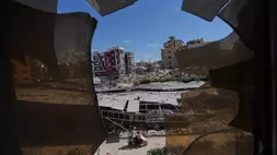 Bangunan-bangunan yang rusak akibat serangan Israel terlihat melalui pecahan kaca dari Rumah Sakit Jabal Amel di kota pelabuhan Tyre, Lebanon selatan pada Kamis (18/6/2026). (Foto: AP/ Hassan Ammar)