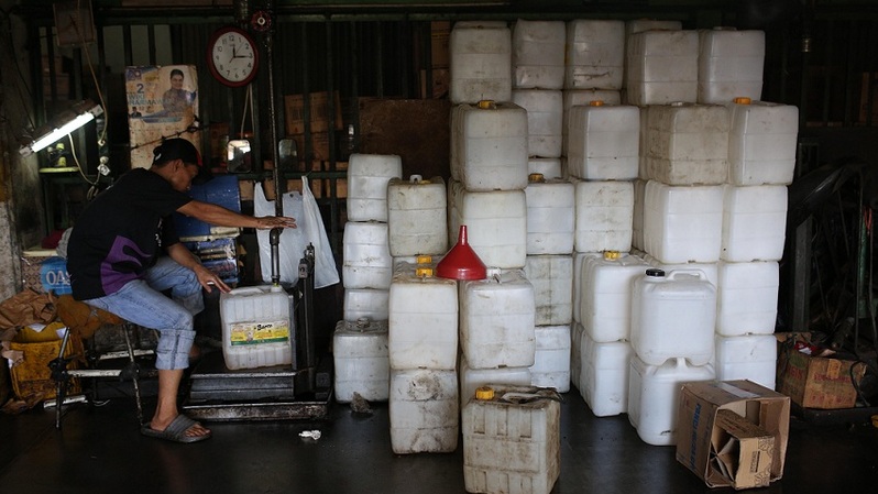Pekerja mengisi minyak goreng curah ke dalam derigen literan di kawasan Cipete, Jakarta Selatan, Jumat (3/12/2021). Foto: BeritaSatuPhoto/Joanito De Saojoao