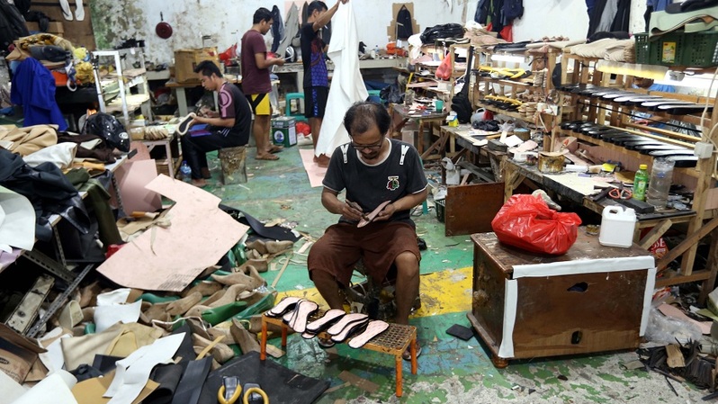 Pekerja menyelesaikan pembuatan sandal wanita di pabrik sepatu rumahan di Pamulang, Tangerang Selatan, Banten, Selasa (22/2/2022). Foto ilustrasi: BeritaSatu Photo/Mohammad Defrizal