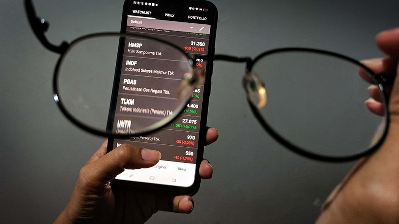 Investor melihat pergerakan harga saham melalui layar ponsel di Depok, Jawa Barat. Foto ilustrasi: BeritaSatu Photo/Mohammad Defrizal