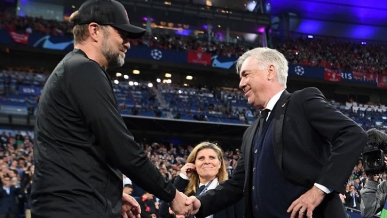 Pelatih Real Madrid Carlo Ancelotti menyalami pelatih Liverpool Jurgen Klopp (kiri) menjelang final Liga Champions antara Liverpool dan Real Madrid di Stade de France di Saint-Denis, Paris, 28 Mei 2022. (Photo by FRANCK FIFE / AFP) (AFP/FRANCK FIFE)