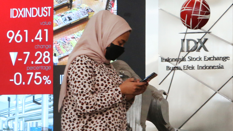 Karyawan melintas di depan monitor saham Bursa Efek Indonesia, Jakarta. (B Universe Photo/Uthan AR)
