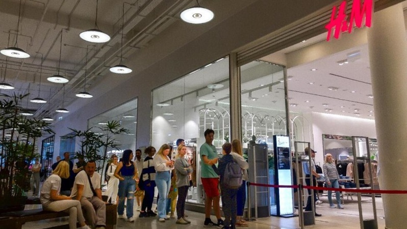 Orang-orang mengantre untuk memasuki toko H&M dan membeli barang-barang yang diobral di pusat perbelanjaan Aviapark di Moskow, Rusia pada 9 Agustus 2022, saat H&M dan IKEA menjual produk inventaris terakhirnya di Rusia. (Foto: AP/Alexander Zemlianichenko)