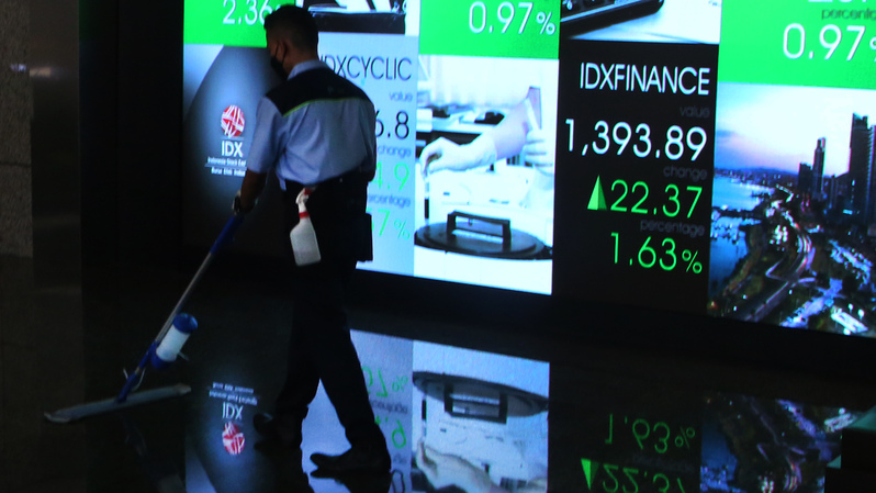 Petugas membersihkan lantai di depan monitor saham di Bursa Efek Indonesia, Jakarta. (B-Universe Photo/UthanAR)