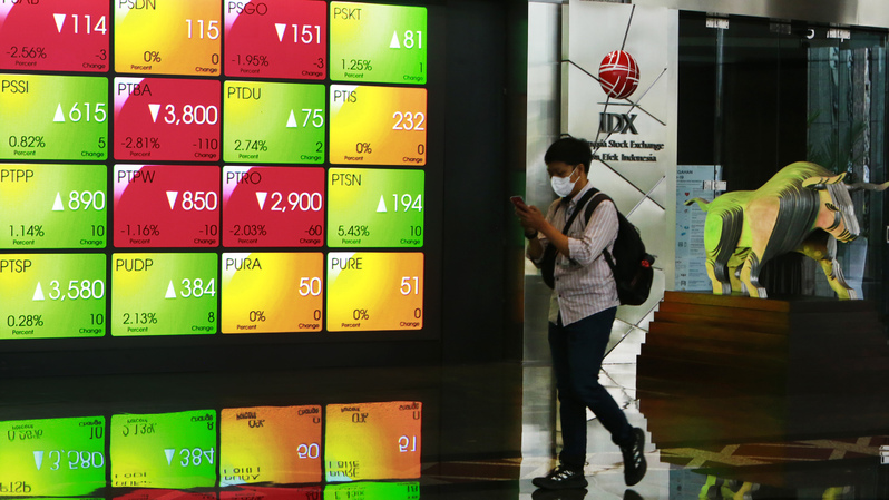 Pengunjung melintas di depan monitor saham di Bursa Efek Indonesia, Jakarta. (B-Universe Photo/Uthan AR)