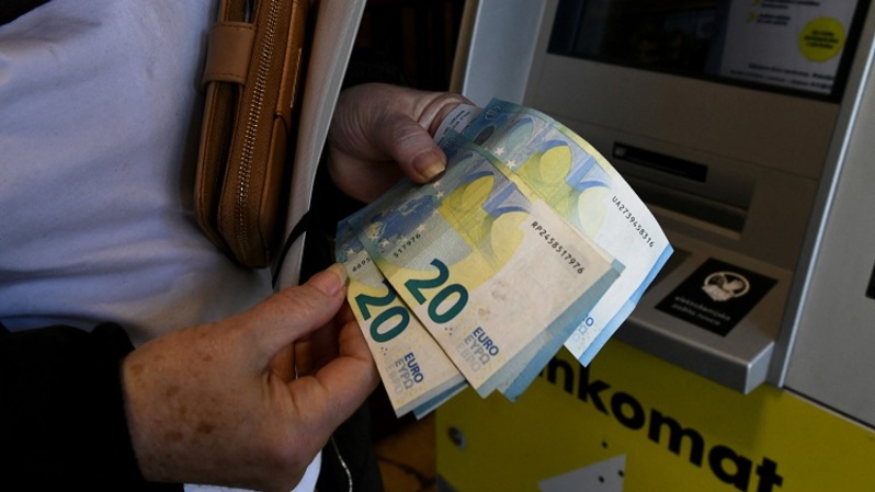 Seorang wanita menarik uang kertas euro dari ATM di Zagreb, Kroasia pada 2 Januari 2023. Sejak 1 Januari 2023, euro menjadi mata uang resmi di negara tersebut. (Foto: Denis LOVROVIC / AFP)