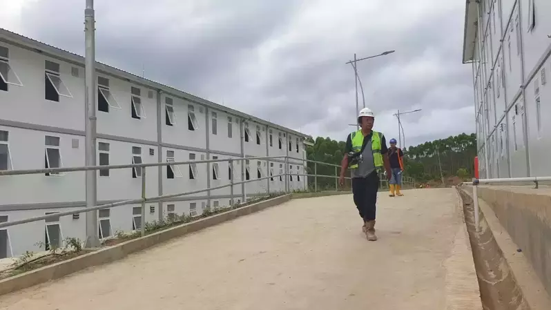 Seorang pekerja melintas di proyek pembangunan hunian pekerja konstruksi (HPK). Rumah ini diperkirakan bakal tampung 16 ribu pekera.