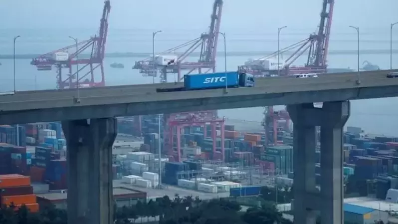 Sebuah truk yang membawa kontainer melewati derek di Pelabuhan Pyeongtaek, Korea Selatan pada 9 Juli 2020. (Foto: REUTERS/Kim Hong-Ji)