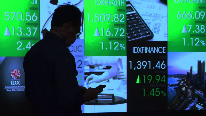 Pengunjung melintas di depan monitor saham Bursa Efek Indonesia, Jakarta. (B-Universe Photo/Uthan AR)