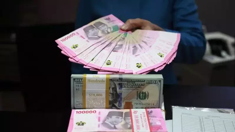 Petugas menunjukkan uang dolar AS dan uang rupiah di salah satu kantor cabang PT. Bank Mandiri Persero Tbk, Jakarta pada 31 Januari 2023. (Foto: ANTARA FOTO/Reno Esnir/tom)