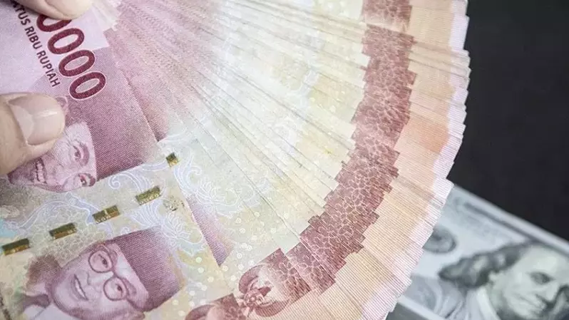Petugas menunjukan uang pecahan rupiah dan dolar AS di gerai penukaran mata uang asing VIP (Valuta Inti Prima) Money Changer di Jakarta pada 3 Januari 2023. (Foto: ANTARA FOTO/Muhammad Adimaja/foc/pri)