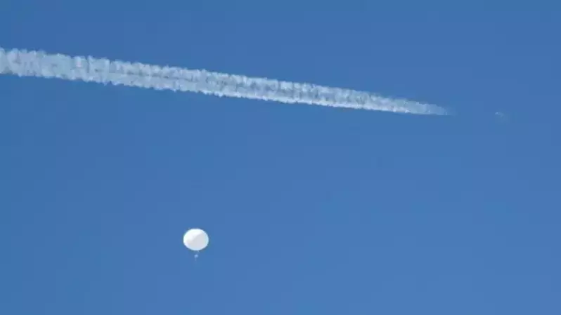 Sebuah jet terbang dengan balon mata-mata yang dicurigai milik Tiongkok saat mengapung di lepas pantai di Surfside Beach, Carolina Selatan, Amerika Serikat pada 4 Februari 2023. (Foto: Randall Hill / Reuters)
