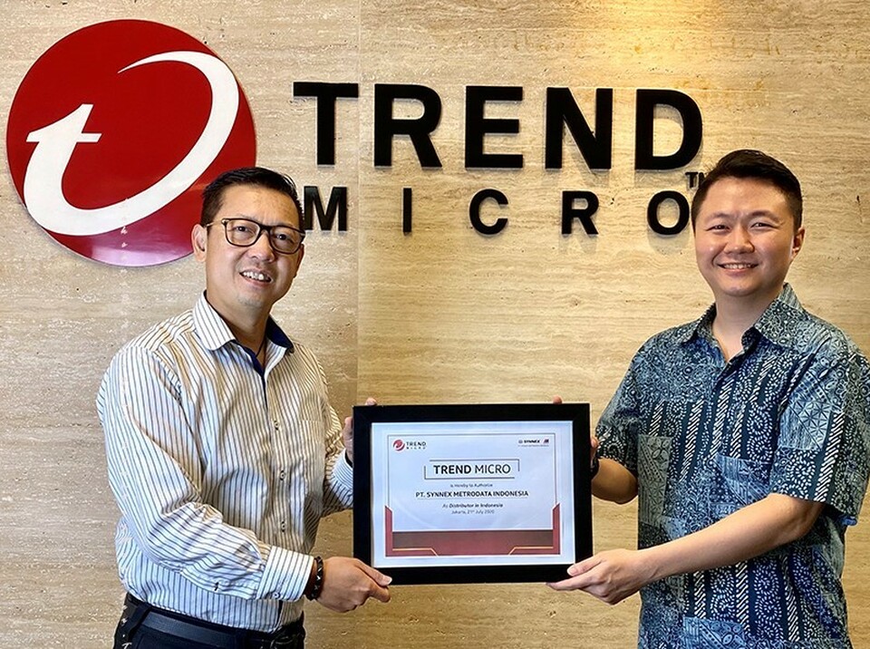 Solution Business Director SMI Andy Komala (kanan) menerima plakat penunjukan authorized distributor solusi keamanan dari Country Manager Trend Micro Indonesia Laksana Budiwiyono (kiri). (IST)


