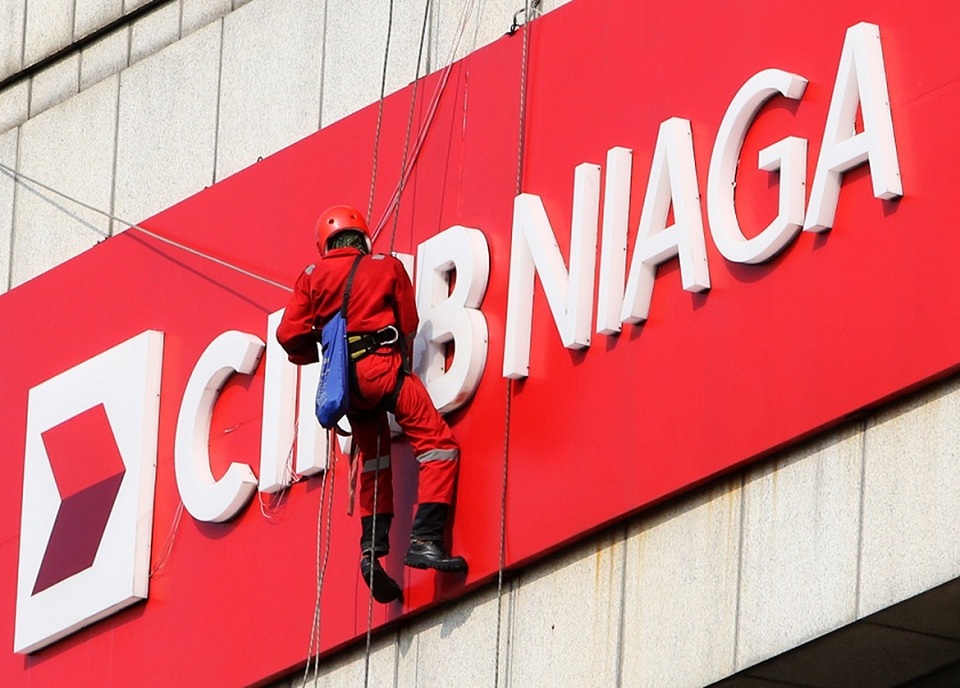 Pekerja sedang membersihkan logo Bank CIMB Niaga di Jakarta. Foto ilustrasi:  Beritasatu Photo/Uthan AR