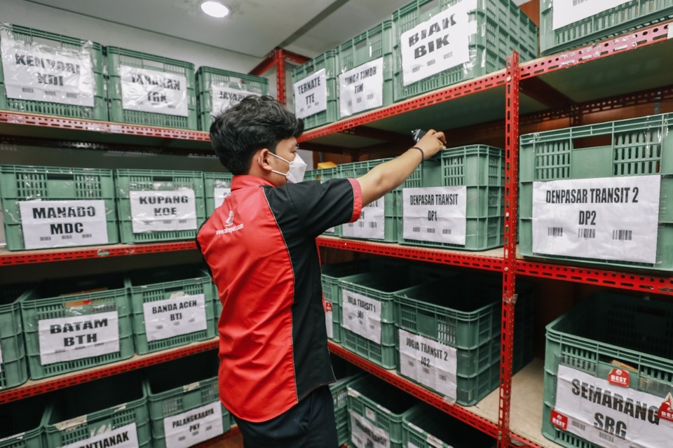 Karyawan SiCepat Ekspres sedang merapikan paket pelanggan.