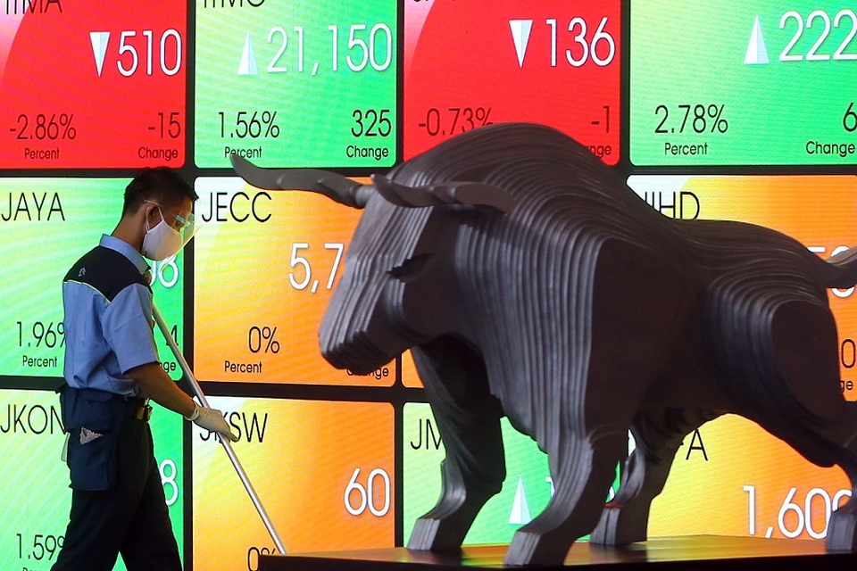 Petugas kebersihan beraktivitas di dekat patung banteng wulung di Bursa Efek Indonesia (BEI), di Jakarta. Foto: BeritaSatu Photo/Mohammad Defrizal