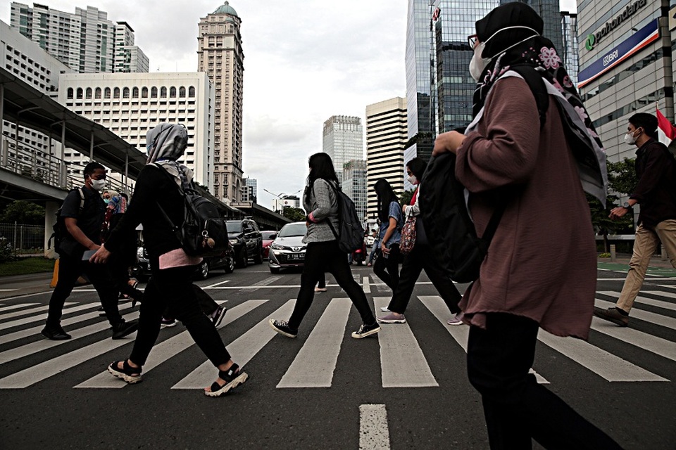 Para pekerja melintas di Jalan Jend Sudirman, Jakarta Pusat. (Foto ilustrasi: B-Universe Photo/Joanito De Saojoao)