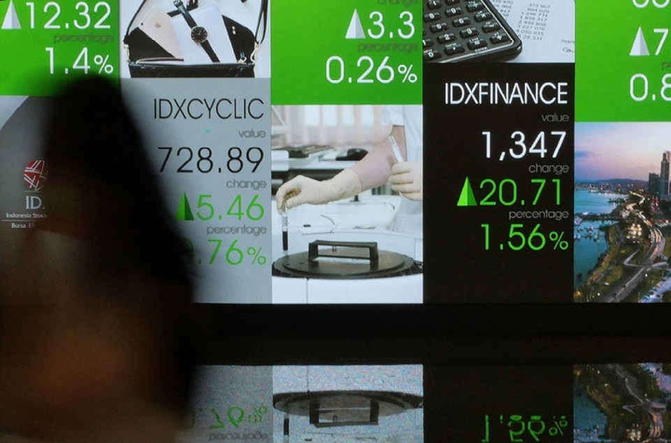 Pekerja melintasi layar pergerakan saham di gedung BEI, Jakarta. Foto ilustrasi: Investor Daily/David Gita Roza