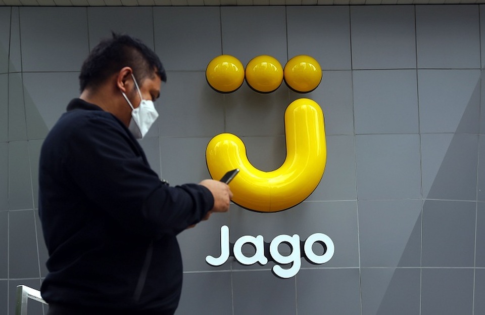 Karyawan melintas di depan logo Bank Jago di Jakarta.  Foto ilustrasi: BeritaSatu Photo/Mohammad Defrizal
