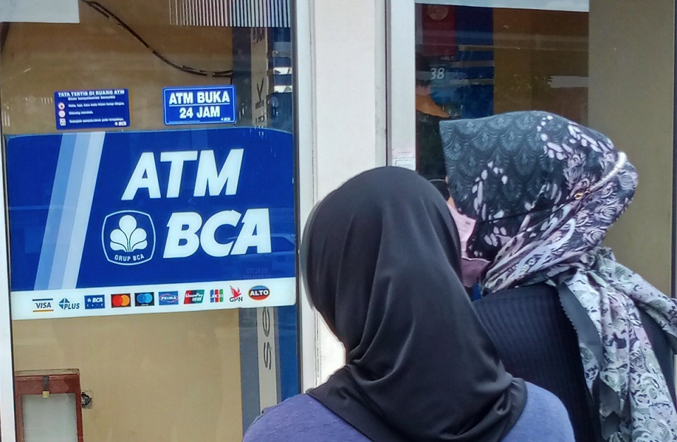 Nasabah antre untuk melakukan transaksi di salah satu mesin anjungan tunai mandiri (ATM), BCA di Depok, Selasa (8/3/2022).  Foto ilustrasi: BeritaSatu Photo/Mohammad Defrizal