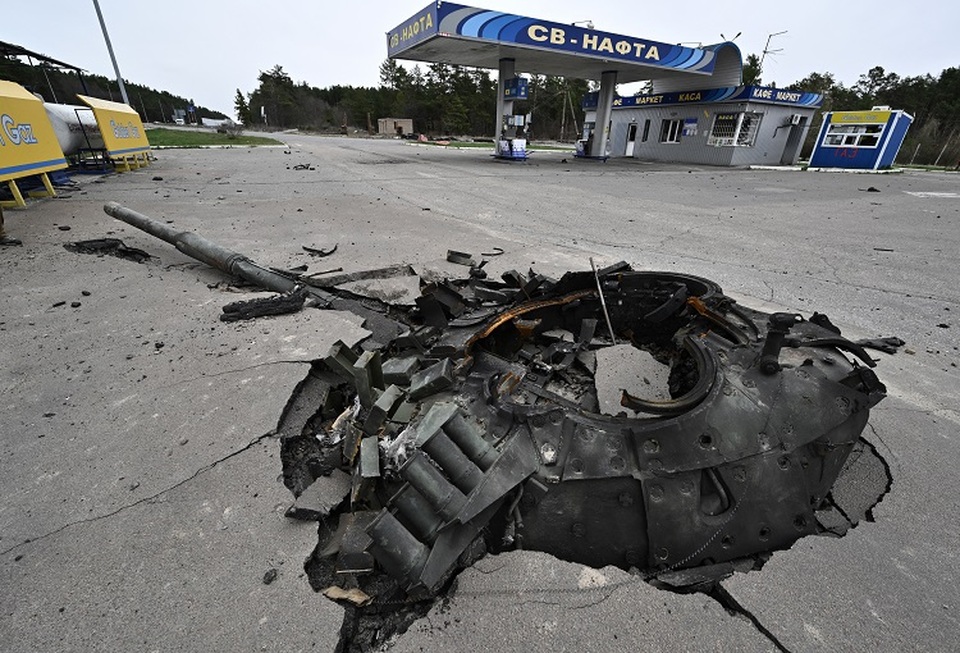 Puing-puing tank Rusia yang hancur di sebuah pompa bensin rusak di dekat Zalissya, timur laut Kyiv, Ukraina pada 12 April 2022. (FOTO: GENYA SAVILOV / AFP)