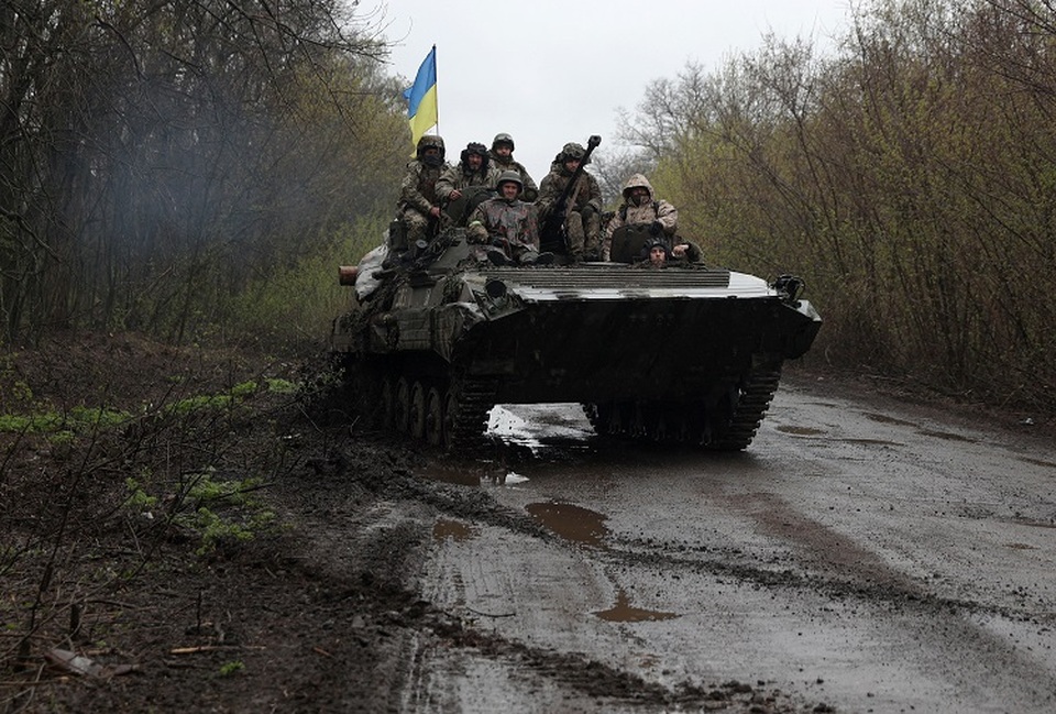 Tentara Ukraina berdiri di atas kendaraan pengangkut personel lapis baja (APC), tidak jauh dari garis depan dengan pasukan Rusia, di Distrik Izyum, Kharkiv pada 18 April 2022. (FOTO: ANATOLII STEPANOV / AFP)