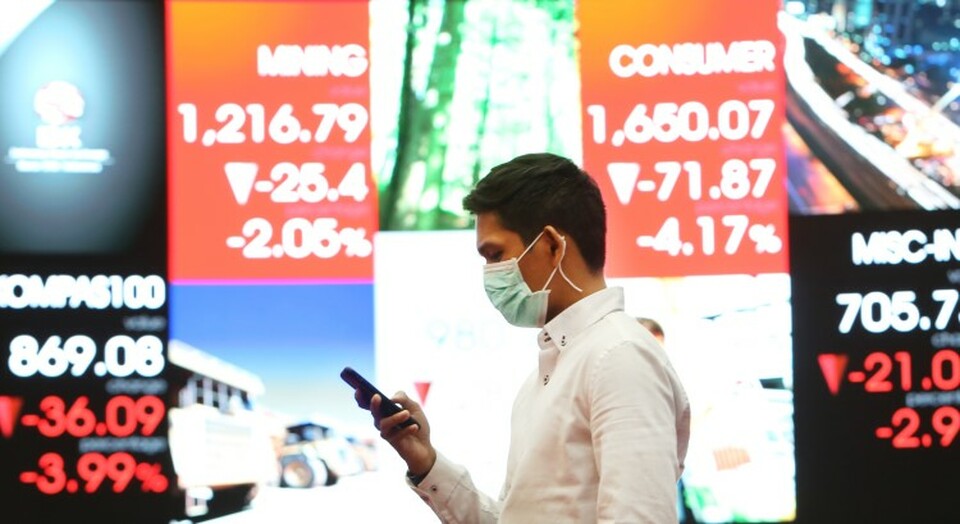 Karyawan melintas di depan monitor saham IHSG di Bursa Efek Indonesia, Jakarta. Beritasatu Photo/Uthan AR
