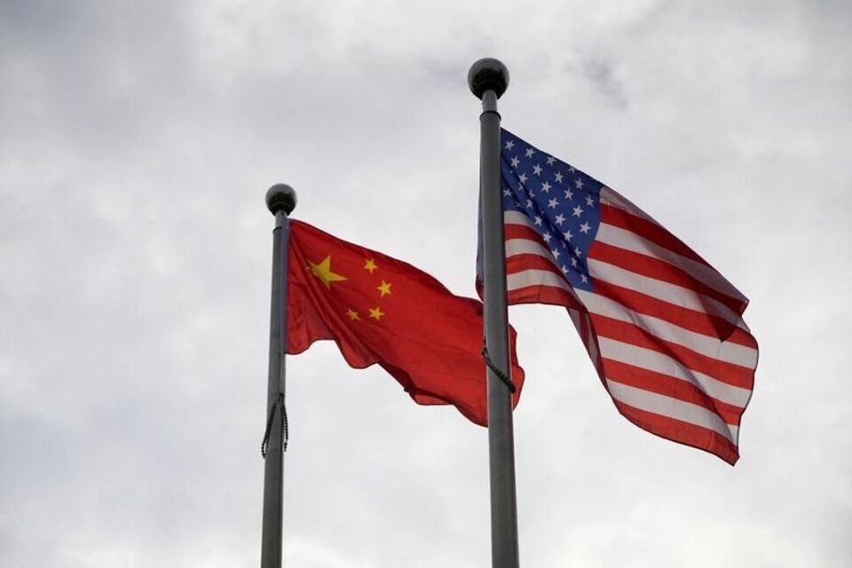 Bendera Tiongkok dan AS berkibar di luar gedung perusahaan di Shanghai, Tiongkok pada 16 November 2021. (FOTO: REUTERS/Aly Song/File Photo)