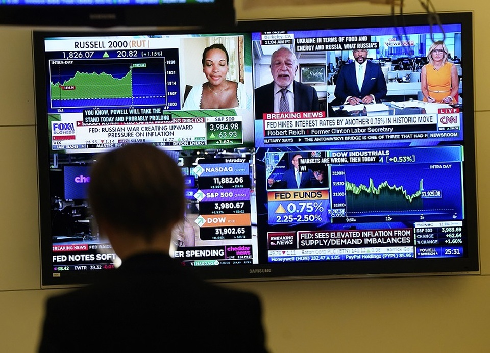 Seseorang di lantai Bursa Efek New York (NYSE) menonton layar TV pada 27 Juli 2022. (FOTO: TIMOTIUS A. CLARI / AFP)