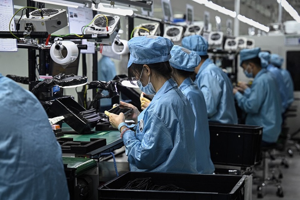 Karyawan bekerja di jalur perakitan ponsel pintar di pabrik Oppo Dongguan, Provinsi Guangdong selatan Tiongkok pada 20 Juli 2022. (FOTO: Giok GAO / AFP)
