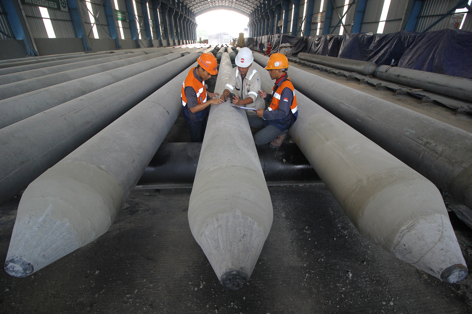 Pekerja memeriksa kualitas ketebalan tiang pancang di salah satu plant Grup Waskita. (ANTARA FOTO/Moch Asim/ama)