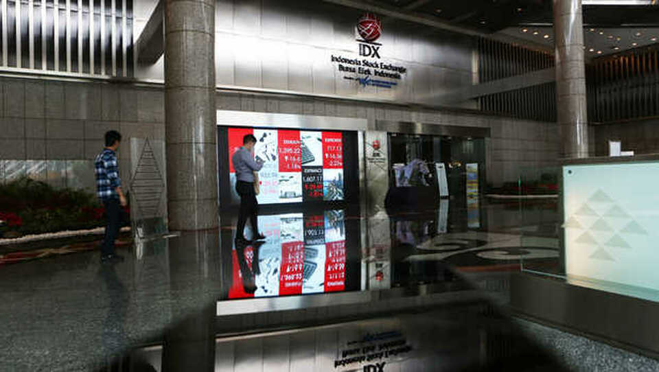 Karyawan melintas di depan monitor saham di Bursa Efek Indonesia (BEI), Jakarta. (Foto ilustrasi: BeritaSatu Photo/Uthan A Rachim)	