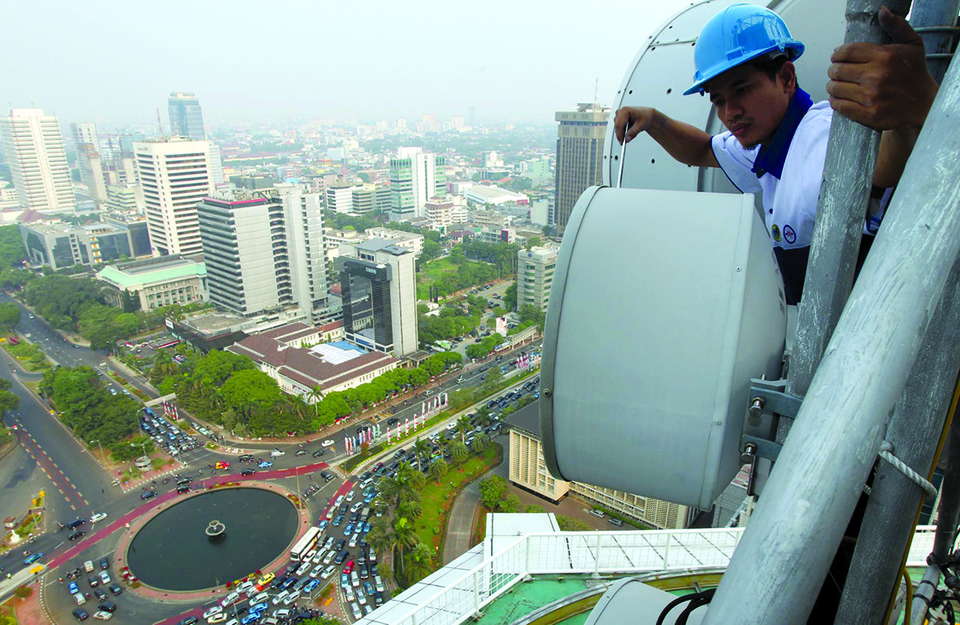 Teknisi melakukan perawatan fasilitas antena gelombang pendek Indosat di Jakarta. (Dok. BeritaSatu Photo)