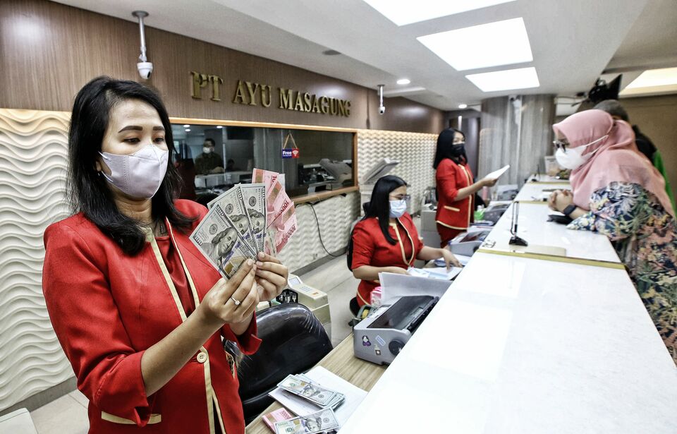 Petugas jasa penukaran mata uang asing menunjukan pecahan uang dolar Amerika Serikat dan pecahan uang Rupiah di tempat jasa penukaran uang di Kwitang, Jakarta Pusat. (Foto: BeritaSatuPhoto/Joanito De Saojoao)