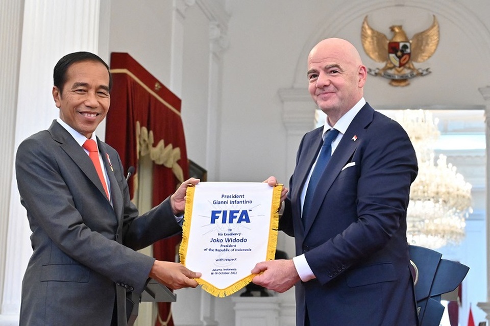 Presiden badan sepak bola dunia FIFA Gianni Infantino (kanan) memberikan cinderamata kepada Presiden RI Joko Widodo saat pernyataan pers bersama di Istana Kepresidenan di Jakarta pada 18 Oktober 2022. (FOTO: ADEK BERRY / AFP)