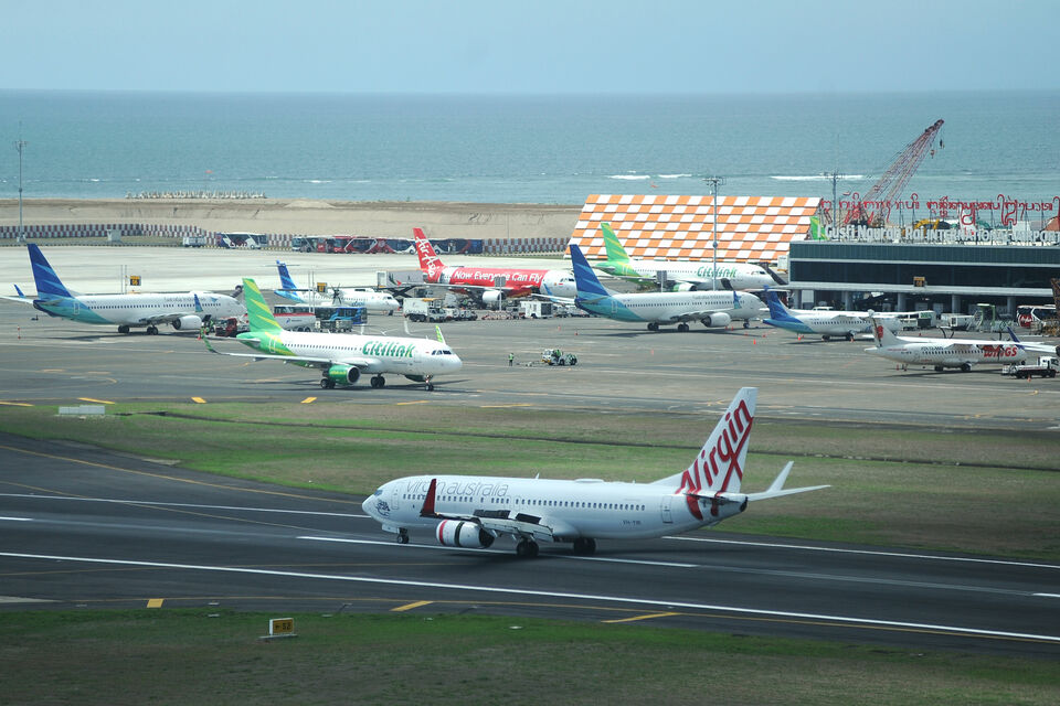 Sejumlah pesawat udara berada di apron dan landasan Bandara Internasional I Gusti Ngurah Rai, Bali. (ANTARA FOTO/Fikri Yusuf/aww) 