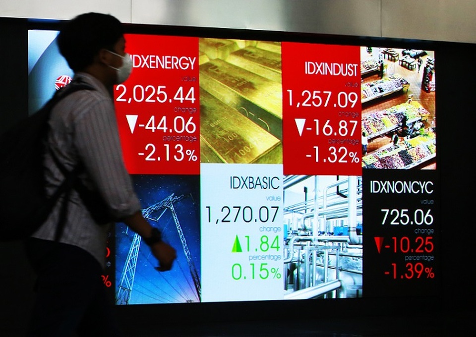 Karyawan melintas di depan monitor saham Bursa Efek Indonesia, Jakarta. (B Universe Photo/Uthan AR)