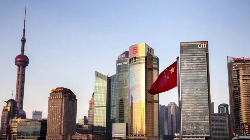 Bendera Tiongkok berkibar di depan gedung pencakar langit perusahaan multinasional pada 23 Februari 2018 di Shanghai, Tiongkok. (Foto: Vincent Isore / IP3 / Getty Images)