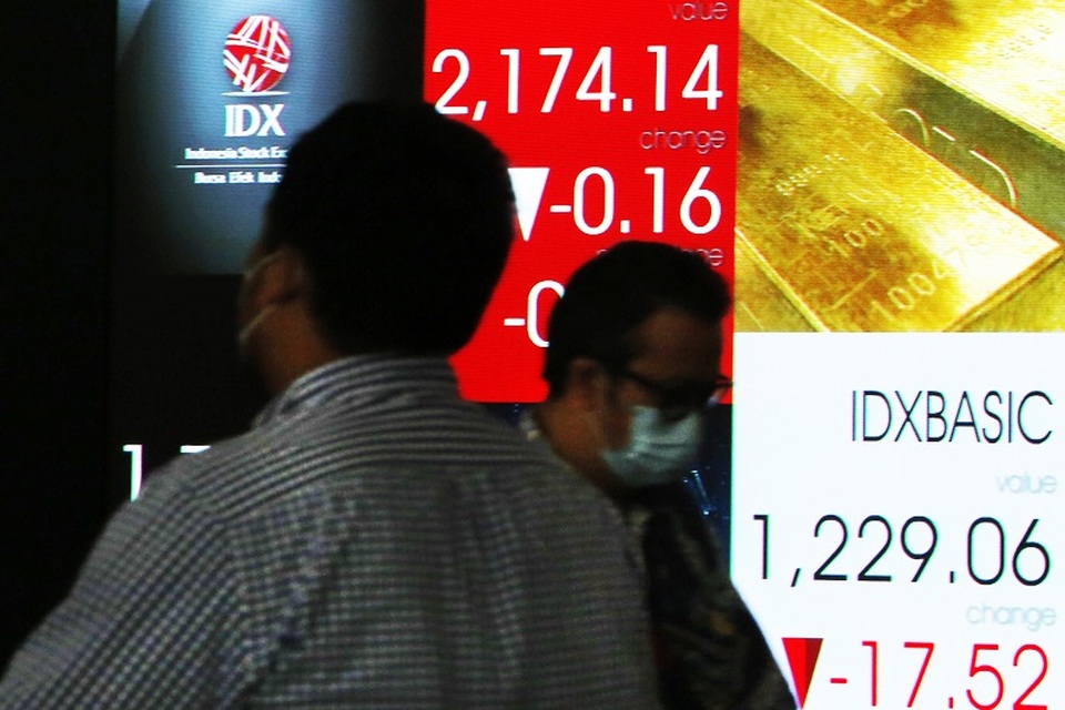 Pengunjung melintas di depan monitor saham Bursa Efek Indonesia, Jakarta. (B-Universe Photo/Uthan AR)