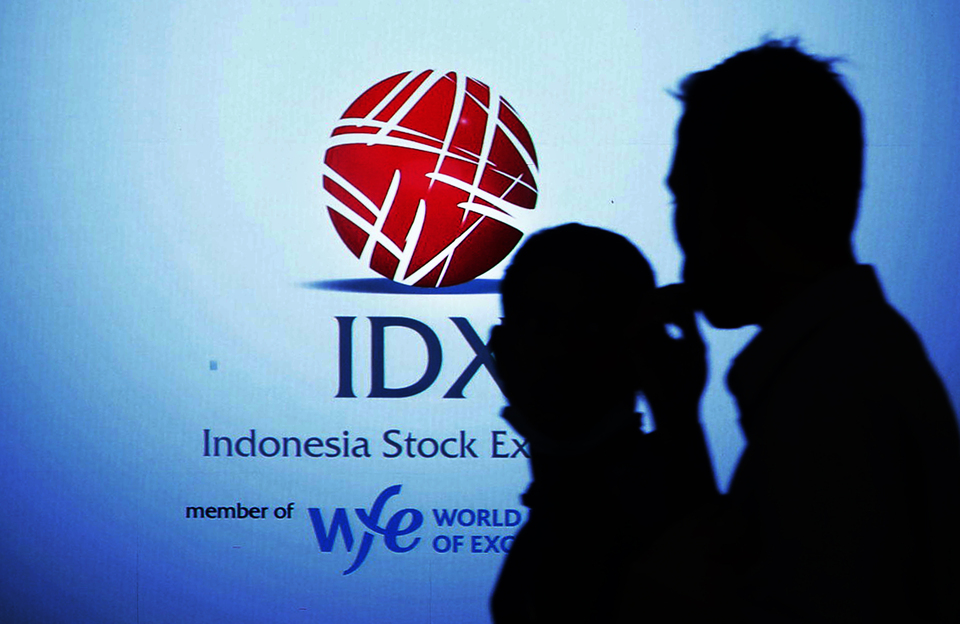 Karyawan melintas di depan logo IDX di Bursa Efek Indonesia, Jakarta. (B-Universe Photo/Uthan AR)