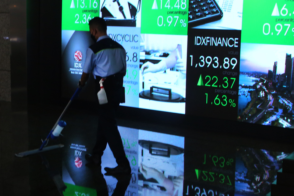 Petugas membersihkan lantai di depan monitor saham di Bursa Efek Indonesia, Jakarta. (B-Universe Photo/UthanAR)