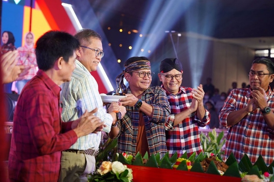 Direktur Utama SIG, Donny Arsal (ketiga kiri) menyerahkan potongan tumpeng kepada Komisaris Utama SIG, Rudiantara (kedua kiri) pada acara perayaan HUT ke-10 SIG di Sasono Langen Budoyo TMII, Jakarta, pada