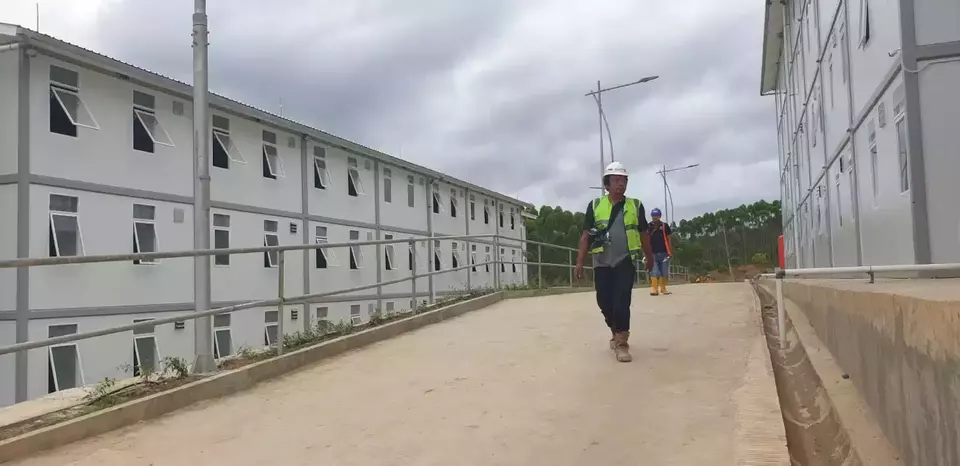 Seorang pekerja melintas di proyek pembangunan hunian pekerja konstruksi (HPK). Rumah ini diperkirakan bakal tampung 16 ribu pekera.