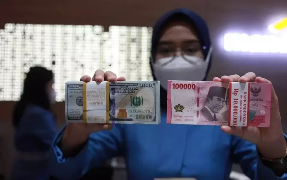 Petugas menunjukkan uang dolar Amerika Serikat (AS) dan uang rupiah di salah satu kantor cabang PT. Bank Mandiri Persero Tbk, Jakarta pada 31 Januari 2023. (Foto: ANTARA FOTO/Reno Esnir/tom)