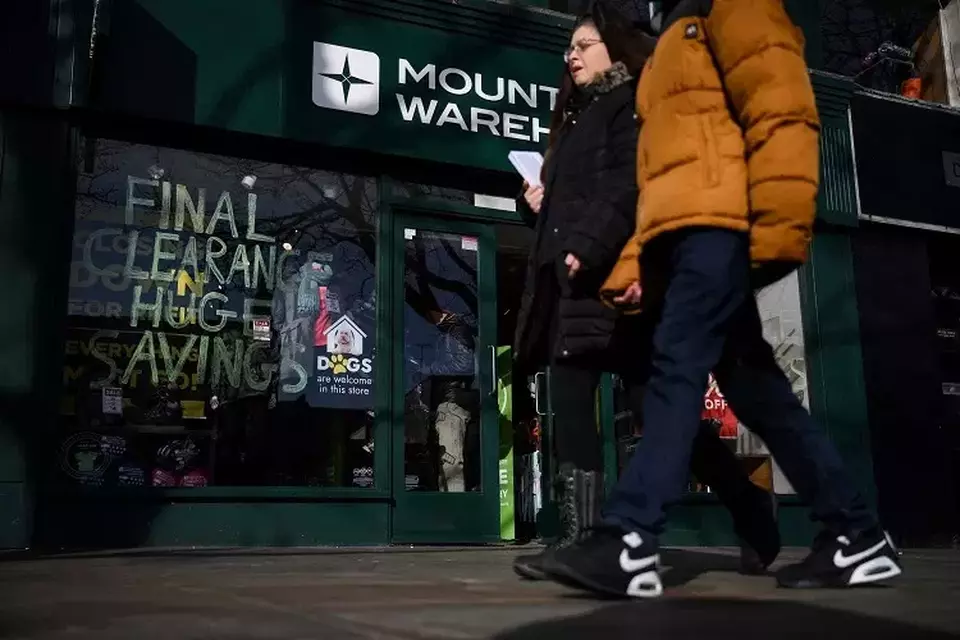 Pejalan kaki melewati toko yang mengiklankan penjualan akhir sebelum clearance sale di wilayah Islington, pusat utara London, Inggris pada 10 Februari 2023. (Foto: Daniel LEAL / AFP)