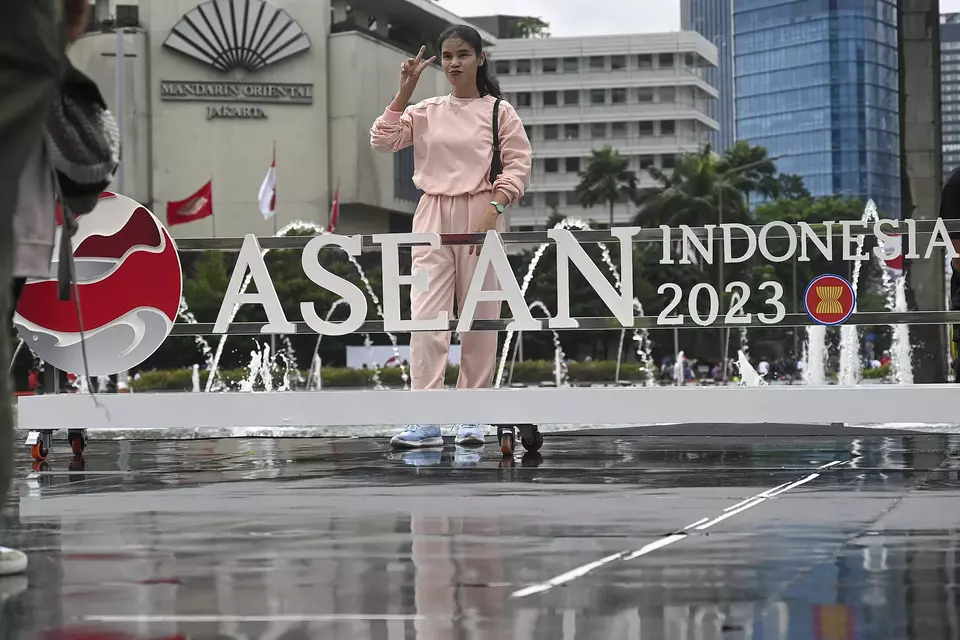 Seorang wanita berfoto bersama logo Perhimpunan Bangsa Bangsa Asia Tenggara (Asean) yang baru. Indonesia secara resmi menjadi ketua Asean setelah acara Kick Off Keketuaan Indonesia di Asean 2023 pada Minggu (29/01/2023). (Foto: Goh Chai Hin / AFP)
