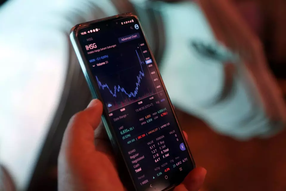 Investor melihat pergerakan indeks harga saham gabungan (IHSG) melalui layer telepon genggam. (B-Universe Photo/Mohammad Defrizal)