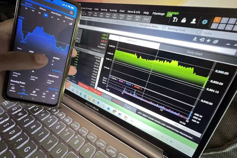 Investor melihat pergerakan harga saham melalui aplikasi. (B-Universe Photo/David Gita Roza)