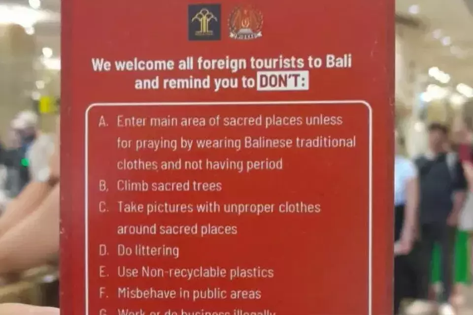 Kartu merah berisi larangan dan kewajiban kepada wisatawan mancanegara saat tiba mengurus pemeriksaan identitas dan paspor di Bandara Internasional I Gusti Ngurah Rai, Bali pada 8 Juni 2023. (Foto: Kemenkumham Bali)